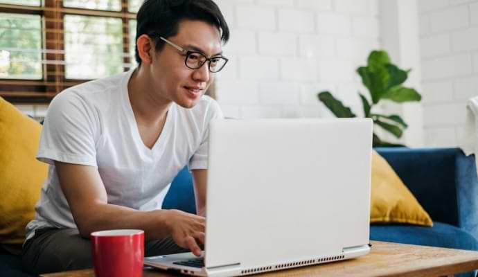 男子边享用美餐边观看手机上正在启动的 Norton 360 入门版。
